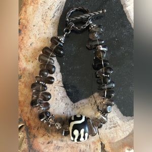 Brown variegated stone bracelet with unusual bead